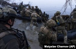 Украинские военнослужащие садятся на катера у берега Днепра в Херсонской области, 15 октября 2023 года
