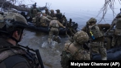 Украинские военнослужащие садятся на катера у берега Днепра в Херсонской области. 15 октября 2023 года