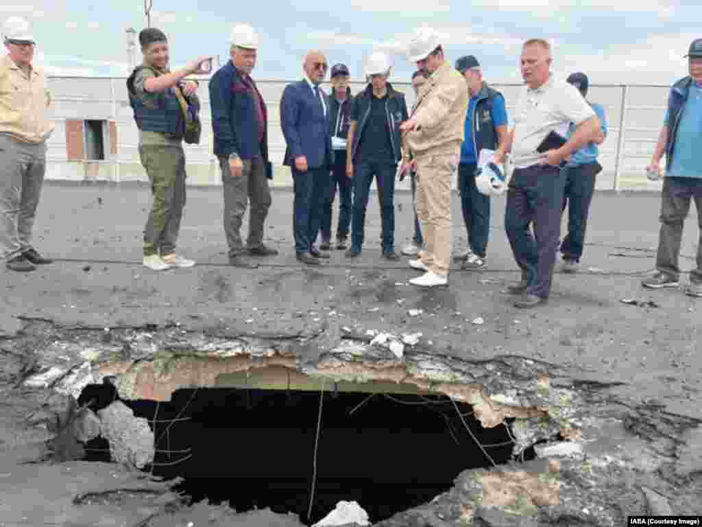 IAEA inspectors, including&nbsp;Rafael Grossi (center right in blue vest), view damage from a shell that landed on a building housing nuclear fuel in September 2022.&nbsp; Details of what was discussed at the closed-door meeting between Grossi and Putin on March 6 are unclear, with the IAEA chief posting a tweet that merely announced an &quot;important exchange&quot; about the ZNPP.&nbsp;