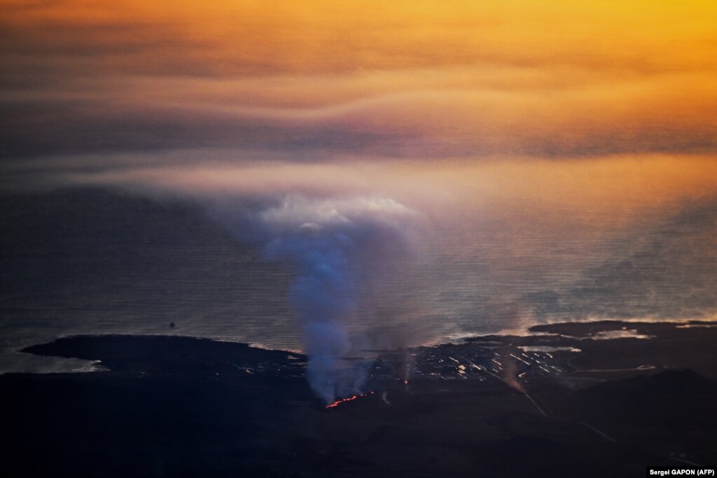 Fotografi e shkrepur nga dritarja e një aeroplani që shfaq shpërthimet the tymin e dendur afër Grindavikut.