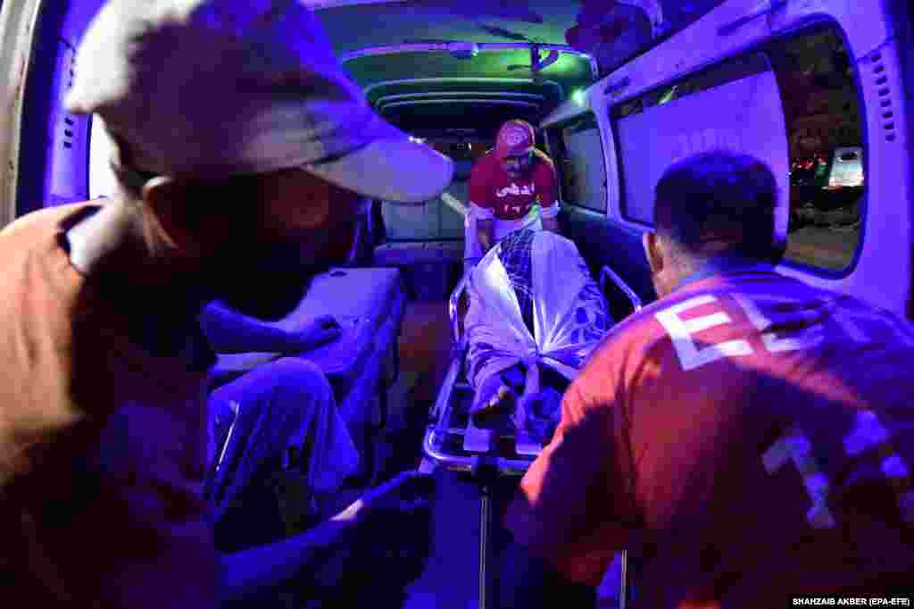 Medics shift the bodies of victims of a bus accident in Balochistan Province to a hospital in Karachi. At least 11 people were killed and 35 injured in the southern province when a bus carrying pilgrims from Iran to Punjab Province fell into a ditch.