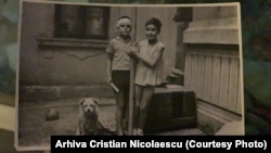 Christian Nicolaescu și sora lui, jucându-se în curtea din spatele casei.