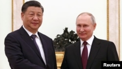 Президент Росії Володимир Путін, ордер на арешт якого видав МКС у Гаазі, тисне руку очільнику Китаю Сі Цзіньпіну під час зустрічі в Кремлі. Москва, Росія, 20 березня 2023 року