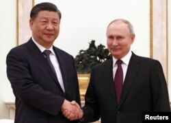 Președintele rus Vladimir Putin și liderul chinez Xi Jinping își strâng mâinile în timpul întâlnirii de la Kremlin, 20 martie 2023.