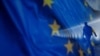 Flamuri i Bashkimit Evropian shihet në prapavijë teksa një njeri ecën. Fotografi ilustruese nga arkivi.