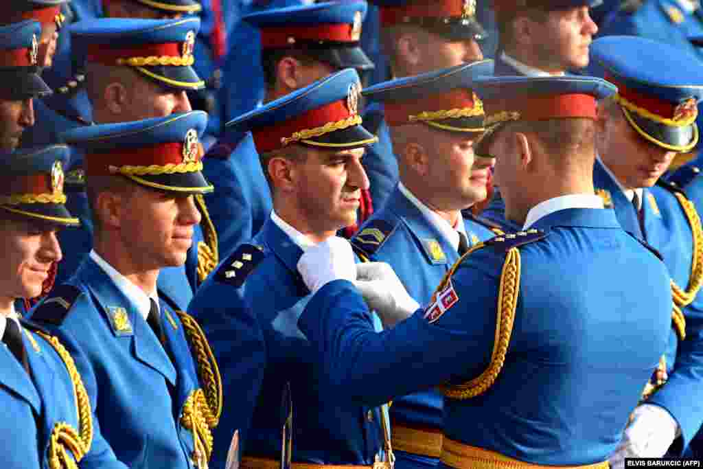 The parade master of the honorary platoon of the Serbian Army fixes a soldier&#39;s uniform prior to a ceremony ahead of French President Emmanuel Macron two-day visit to Belgrade.