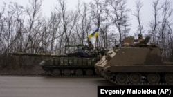 Ukrainian servicemen drive armored vehicles near the frontline city of Bakhmut in the Donetsk region. 