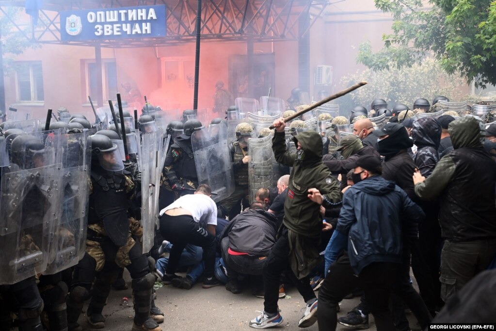Ushtarët e Forcës Paqeruajtëse Ndërkombëtare të Kosovës të udhëhequr nga NATO-ja, përleshen me serbët lokalë përpara ndërtesës komunale në Zveçan, Kosovë.