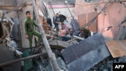 Палестинците бараат спасувачки предмети во урнатините на зграда уништена за време на израелското бомбардирање во Рафах, на југот на Појасот Газа, на 2 декември 2023 година.