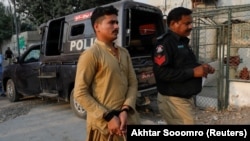 An Afghan national who according to police was undocumented is seen with his hands tied after he was detained and shifted to a holding center in Karachi, Pakistan, on November 1.