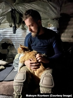 Максим Кривцов із рудим котом, який став постійним супутником його останніх місяців на передовій