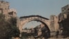 Тази снимка от август 1993 г. е една от последните на оригиналния мост в Мостар, Босна и Херцеговина, известен като Стари мост. Въпреки че е покрит с гуми и дървени дъски, за да бъде предпазен огъня от минохвъргачки и танкове, мостът пада в река Неретва след масирани удари на етнически хърватски сили през ноември 1993 г.