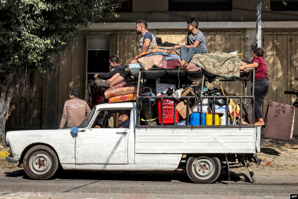 Njerëzit qëndrojnë hipur mbi gjësendet e ngarkuara në një automjet të vjetër në Rafah.