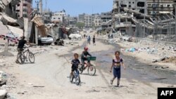 Disa fëmijë kalojnë me biçikleta nëpër një rrugë në Qytetin e Gazës më 3 maj 2024