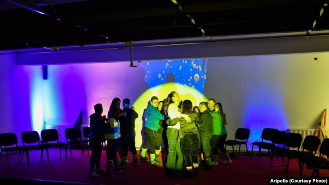 Anëtarët e shoqatës Down Syndrome Kosova në skenën e teatrit të Prizrenit derisa përqafohen me mentoren e tyre, aktoren Blerta Gubetini, pas shfaqjes "Trisomy Love", e organizuar me iniciativë të Artpolis.