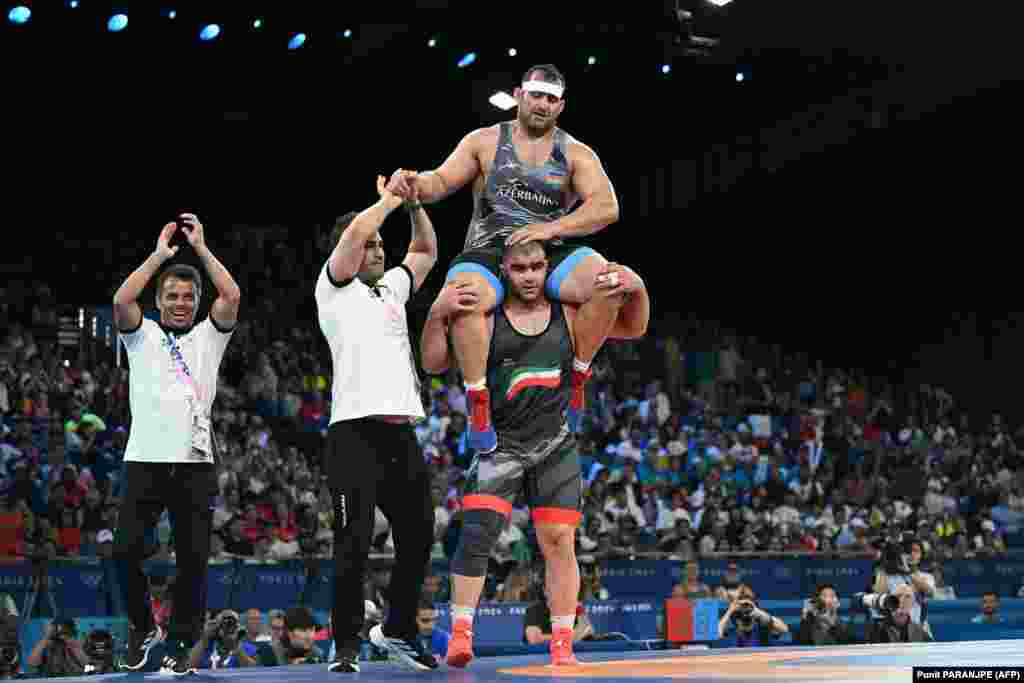 Iran&#39;s Amin Mirzazadeh carries Azerbaijan&#39;s Sabah Saleh Shariati on his shoulders after the latter lost their men&#39;s Greco-Roman 130-kilogram&nbsp;bronze-medal wrestling match on August 6.