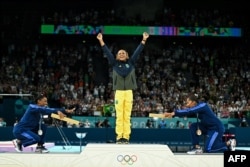 Simone Biles din SUA (stânga), Rebeca Andrade din Brazilia (centru) și Jordan Chiles din SUA (dreapta) pozează în timpul ceremoniei pentru proba feminină de gimnastică artistică la sol, pe 5 august 2024.