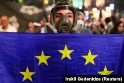 Răspunsul dur al poliției georgiene, care folosește gaze lacrimogene și tunuri cu apă împotriva mulțimii, i-a făcut pe mulți să vină la proteste cu măști de gaz și ochelari.