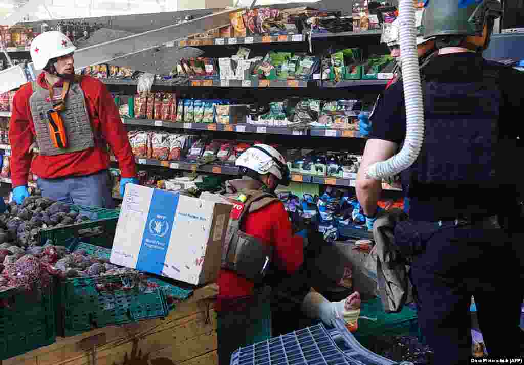 Paramedics help a local resident, wounded in a shopping center following a Russian military strike.