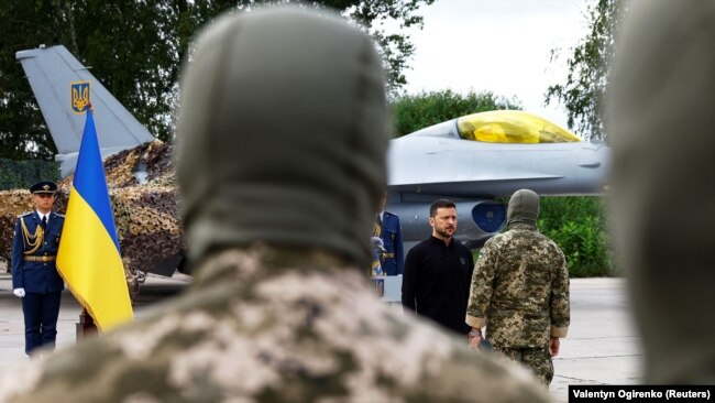 Президент України Володимир Зеленський на тлі винищувача F-16 у День Повітряних сил ЗСУ. Київська область, 4 серпня 2024 року