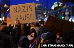 Učesnik drži plakat s natpisom "Nacisti van" tokom demonstracija protiv rasizma i krajnje desničarske politike ispred u Berlinu, 21. 1. 2024.