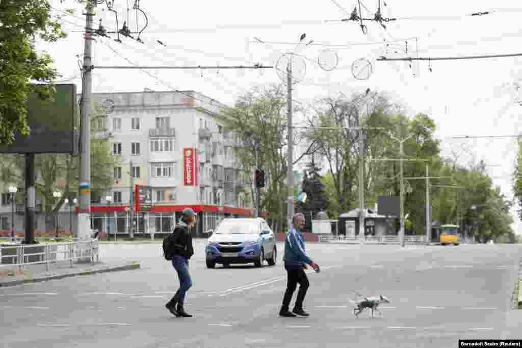 People cross a street in the city center of Kherson after a 58-hour curfew on May 8.