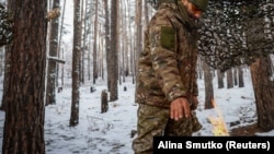 Bir ukrain esgeri gündogar Donetsk sebitindäki front çyzygynyň golaýynda elini oda çoýýar. 23-nji noýabr. 