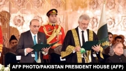 Supreme Court Chief Justice Qazi Faez Isa (front right) administers an oath to newly sworn-in Pakistani President Asif Ali Zardari (front left) at the President House in Islamabad on March 10.