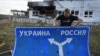 RUSSIA – Ukrainian historian Yuri Savchuk, head of the Kyiv-based Ukrainian WWII history museum, carries a road sign in Sudzha, Kursk region, Russia, August 16, 2024 