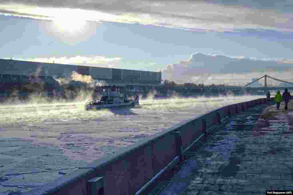 An icebreaker operates on the frozen Moskva River during a cold winter day in Moscow