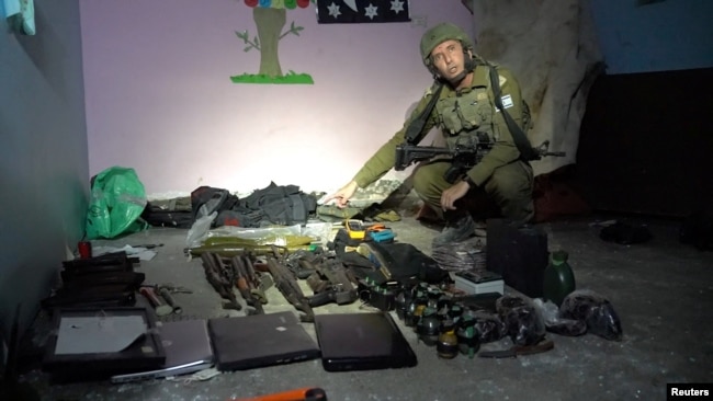 Zëdhënësi i ushtrisë izraelite Daniel Hagari tregon ato që ai thotë se janë armë të ruajtura nga Hamasi në bodrumin e Spitalit pediatrik, Rantissi, në Gazë.