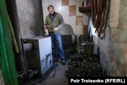 Житель города Алатау Валерий Бочаров показывает, как топит печь углём. Алматинская область, 12 января 2024 года