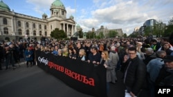 Учасники акції протесту тримають плакат із написом «Сербія проти насильства», Белград 8 травня 2023 року. Протестувальники вимагали відставки посадовців і обмеження насильства в медіа після двох випадків стрілянини