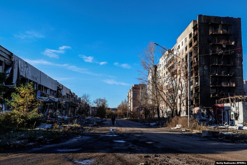 Un residente locale cammina accanto a edifici gravemente danneggiati.   I media locali hanno riferito il 13 novembre che i White Angels hanno evacuato due corpi di vittime uccise in seguito al bombardamento di una zona residenziale ad Avdiyivka.