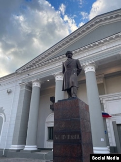 Памятник Пушкину перед разрушенным российскими бомбардировками, а теперь восстановленным театром в Мариуполе