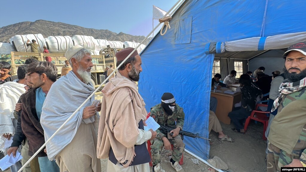 I rimpatriati afghani aspettano di essere registrati sotto l'occhio vigile dei talebani.   