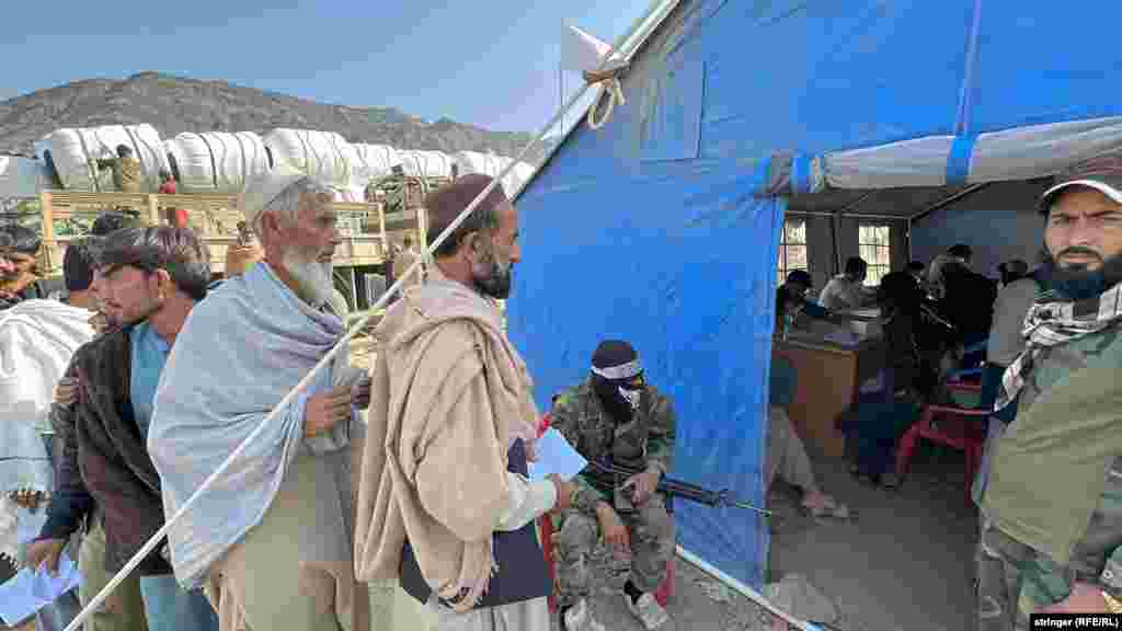 Afghan returnees wait to get registered under the watchful eye of the Taliban. &nbsp;