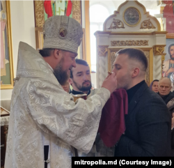 Nicolae Ionichi, primind împărtășanie de la Episcopul Ioan de Soroca, în biserica din satul natal, Gordinești, Rezina, decembrie 2022.