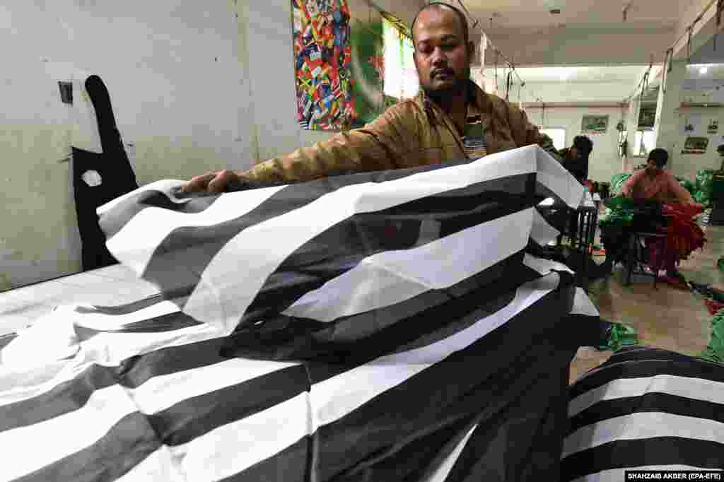A Pakistani worker arranges the flags of Islamic political party Jamiat Ulma-e Islam Fazal (JUI-F) in Karachi. With the elections approaching, printers across Pakistan are working tirelessly to keep up with the demand for campaign posters, flyers, and merchandise.