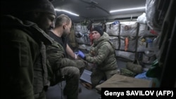 Боевой медик оказывает помощь раненому в эвакуационной машине. Украина, 20 ноября 2023 года