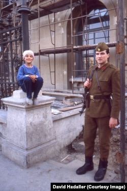 Një ushtar qëndron pranë një vajze të vogël në Bukuresht në marsin e vitit 1990, vetëm tre muaj pas revolucionit të vitit 1989.