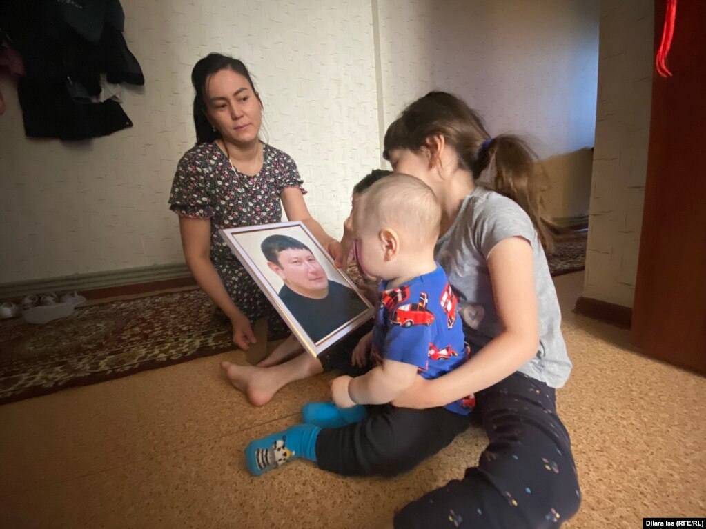 Ырысты Даурбаева с детьми. Старшие дочери показывают младшему фотографию погибшего папы Нурлыбека Асылбекова. Шымкент, 19 апреля 2023 года
