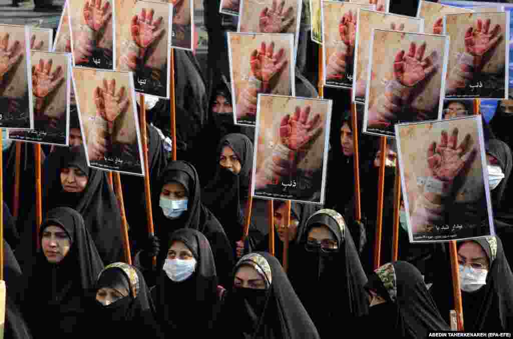 Iranian women hold placards during a march by members of Iranian paramilitary Basij forces in Tehran to show their solidarity with Gaza&#39;s people on November 24.
