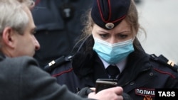 Полицейская на одной из центральных улиц Москвы проверяет цифровой пропуск. 9 мая 2020 года