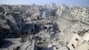 Люди проверяют обломки зданий, разрушенных в результате израильского удара по лагерю беженцев Бурейдж в центральной части сектора Газа 2 ноября 2023 года, на фоне продолжающихся боёв между Израилем и палестинским движением ХАМАС