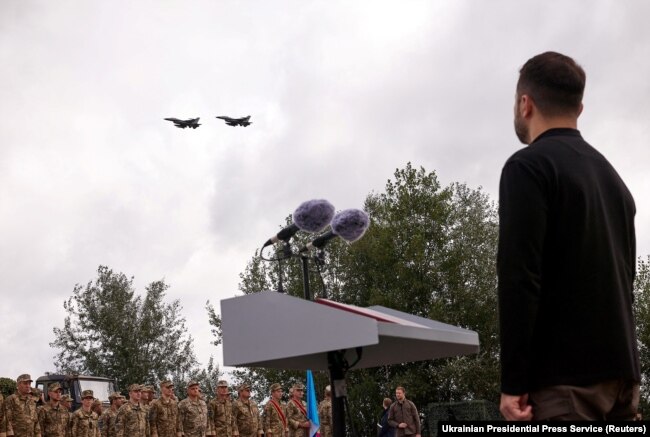 Ukrainian President Volodymyr Zelenskiy watches a flypast of F-16 fighter jets at an unspecified location in Ukraine on August 4. JASSMs can be launched from F-16 fighter jets, which Ukraine now fields in its air force. The &ldquo;standoff&rdquo; missiles are named for their ability to be launched from out of reach of most air-defense systems.