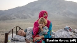 یک مادر مهاجر افغان که با اطفال خود از پاکستان اخراج شده و به افغانستان برگشته است 