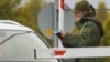 A border guard checks a driver's papers at a crossing between Russia and Finland. (file photo)