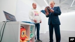 Руският президент Владимир Путин разглежда комикс в анимационното студио "Мечталет" в Хабаровск, 11 януари 2024 г.