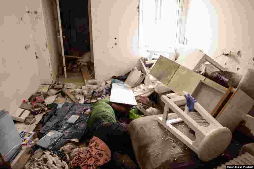 The body of a man lies among rubble following an attack by Hamas gunmen on Kibbutz Kfar Aza in southern Israel on October 10, 2023.